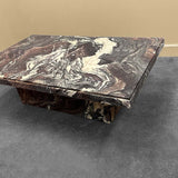 Marble-patterned coffee table on a dark surface with a beige wall background