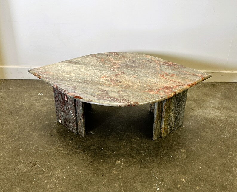 Rustic marble table on a concrete floor with a plain white wall background