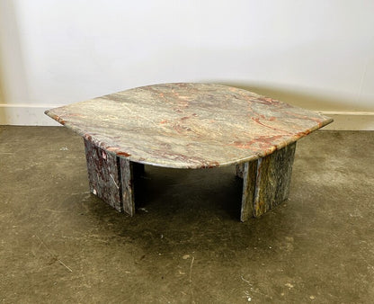 Rustic marble table on a concrete floor with a plain white wall background