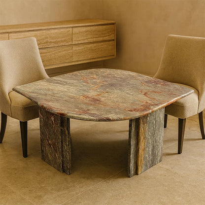 Dining table with marble-like surface and marble legs in a room with beige walls and chairs.