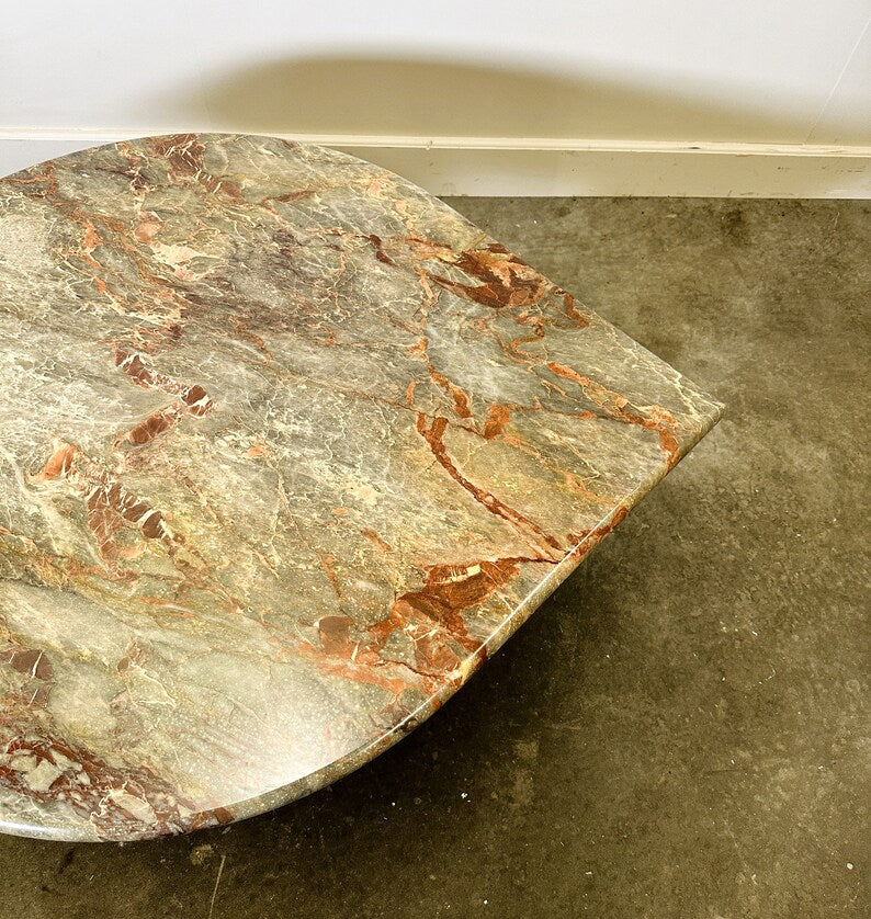 Marble slab with red and gray patterns on a concrete floor